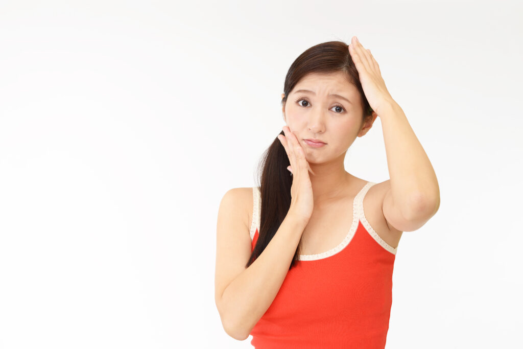 お肌と頭骨を気にする若い女性の写真