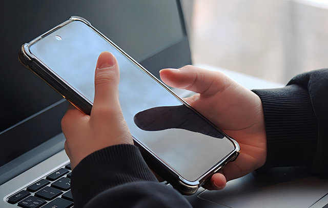 スマホを操作する手とスマホ画面のアップの画像