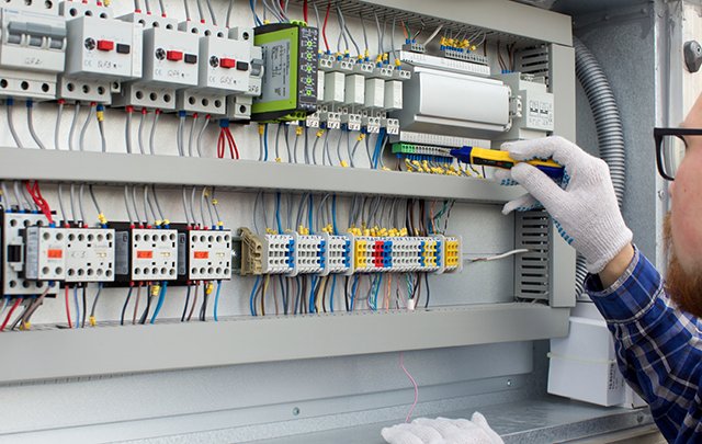 電気回路のスイッチを調整する保安員の画像