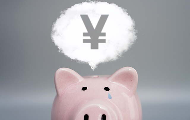 借金のことを考えるブタの貯金箱の画像