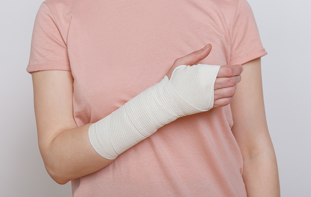 手にギブスをはめて固定している状態の女性の画像
