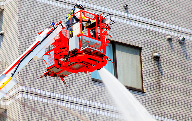消防車がビルに向かって放水している画像