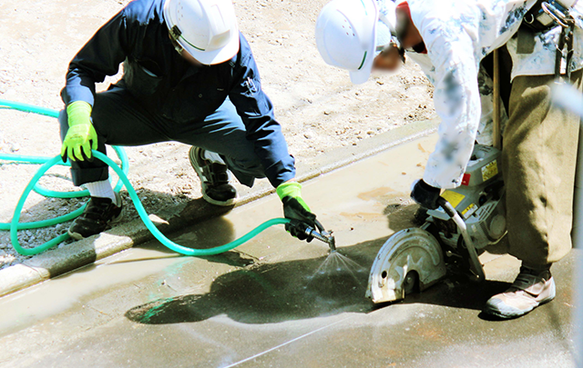 大きな騒音コンクリートを工事用カッターで切断している画像