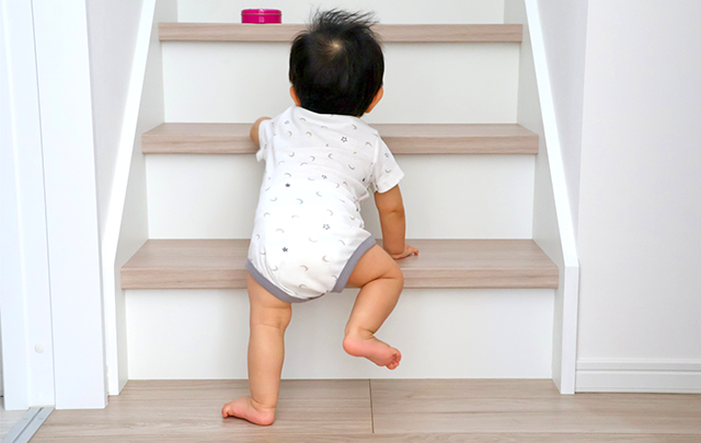 初めて階段を登ろうとする赤ちゃんの画像