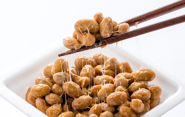 発酵食品の納豆をはしでつまみ上げる画像