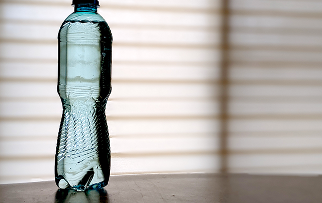 夜間の水分補給たのめにテーブルに置かれたミネラルウォーターのペットボトルの画像