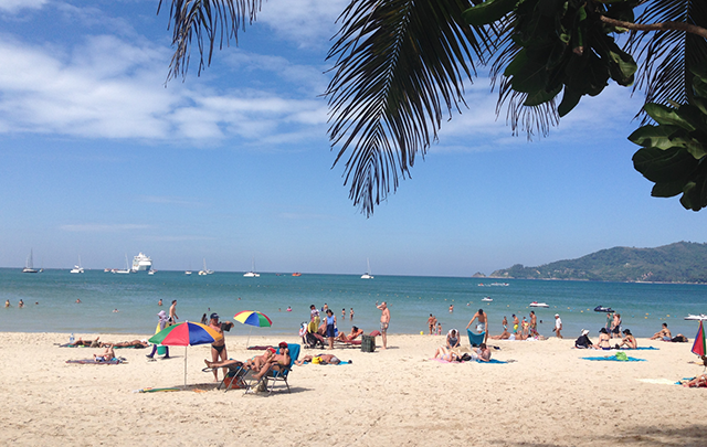 リゾート地の浜辺で日光浴をする複数の観光客の画像