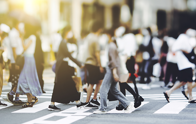 大きな交差点の中の人の波、出ては消えていく様のの夕焼け画像