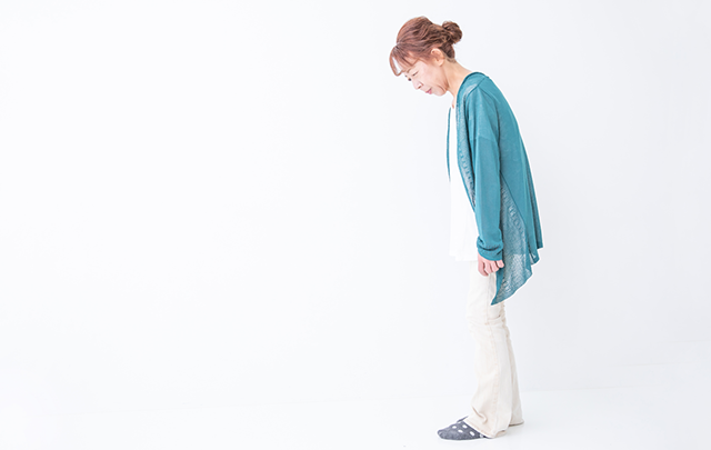 前屈みになった姿勢の悪い中年女性の画像