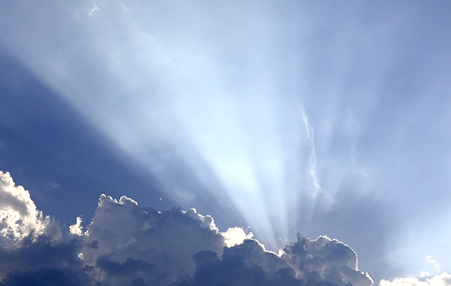 雲の多い空から一条の光がさす神々しいが画像