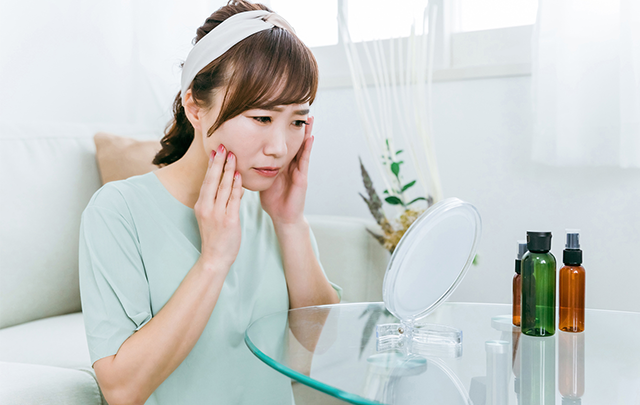 朝メイクに悩んでいる若い女性の画像