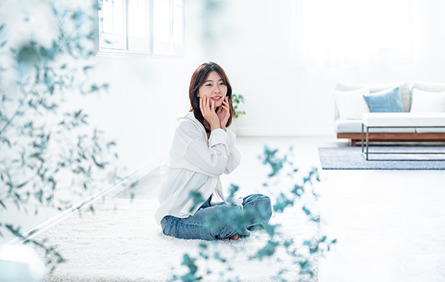 真っ白な部屋の中央で若い女性が、床に座り込んで毎日のお化粧をしている画像