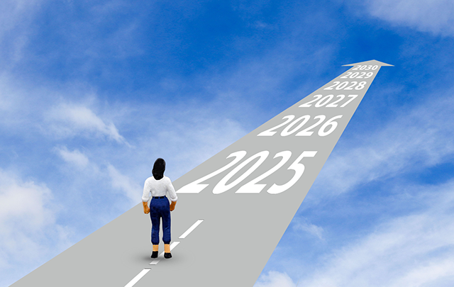 青空に向かって伸びる一本の道の手前、女性が歩き出そうとしている画像