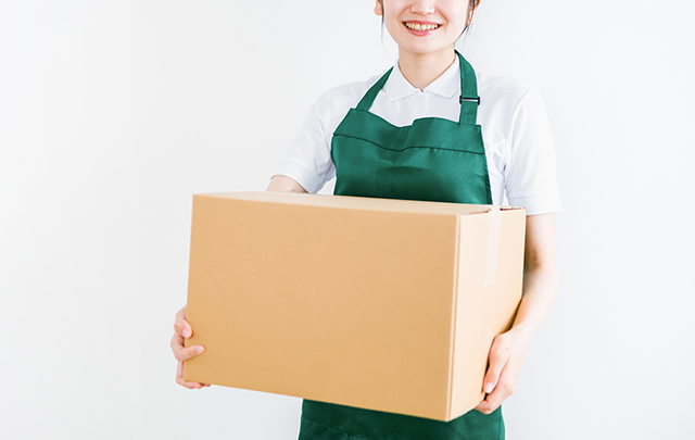 荷物を運ぶ若い女性の画像