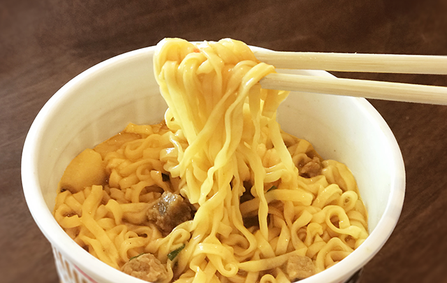 加工食品の代表格カップ麺を掴む箸のある画像