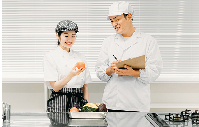 男女の栄養士が二人でメニューの栄養チェックをしている画像