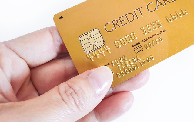 クレジットカードを提示する手指のアップ画像