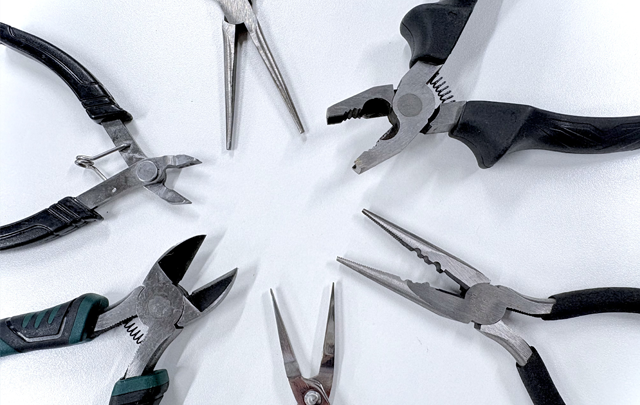 手入れされたペンチなどの工具が円形に多数並んでいる画像