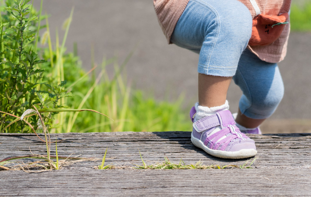 公園のコンクリートの階段を最後を一歩を登り切る女児の画像