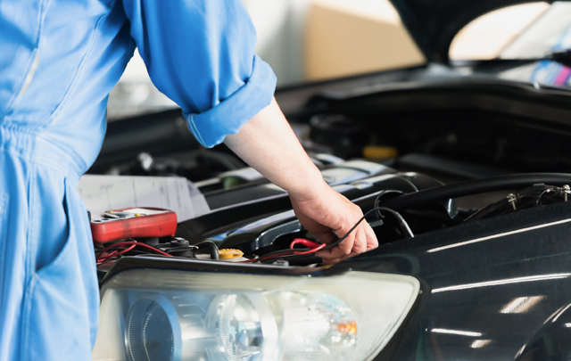 自動車のボンネットを開けて整備士がエンジンを点検している顔図