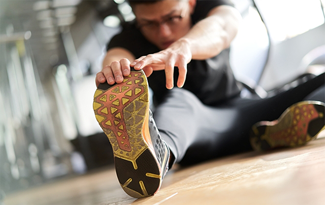 男性がストレッチをして足を伸ばしている画像