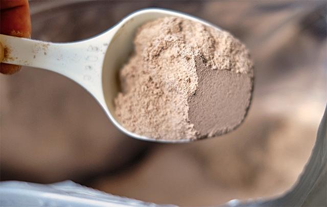 袋からスプーン一杯に取り出したプロテイン粉末の画像