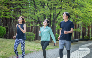 森林の中を走る３人の若い男女の画像