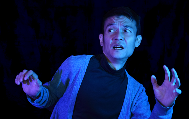 暗闇の中、恐怖で体が固まっている中年男性の画像