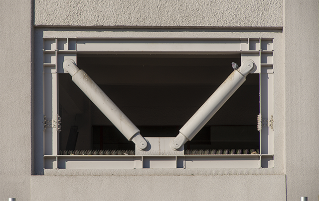 建築物を地震から守るために四角開口部の枠に対角線に設置されたダンパー（衝撃吸収部材）の画像