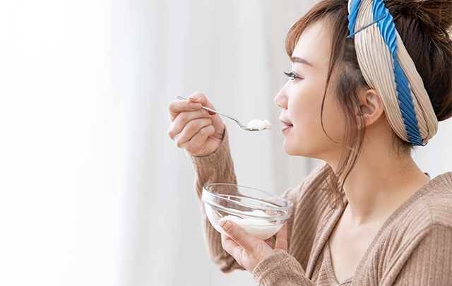 善玉菌を整えるヨーグルトを貯食にとる若い女性の画像