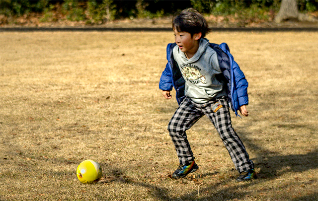 冬の公演で一人サッカーボールで遊ぶ少年の画像