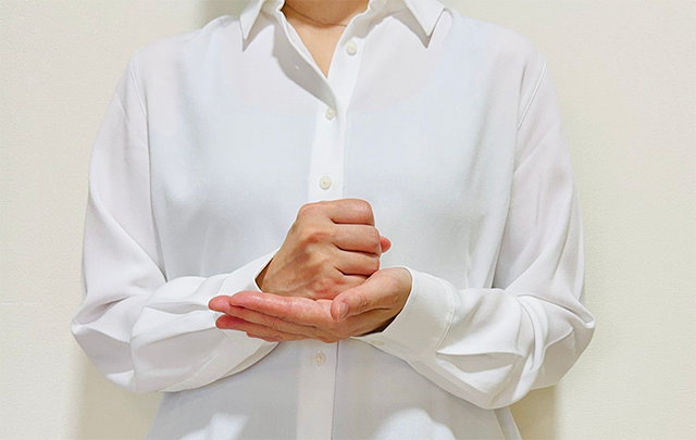 両店で「ガッテン」と手を打っている女性のバストショット画像