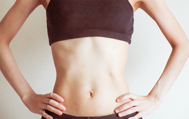 鍛えられた腹筋の女性のボディショット画像