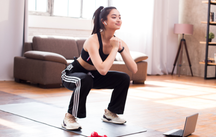 日常的に自宅で絵スクワットをする若い女性の画像