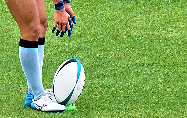 ラグビーの選手がボールキックするためにセットアップしている様子の画像